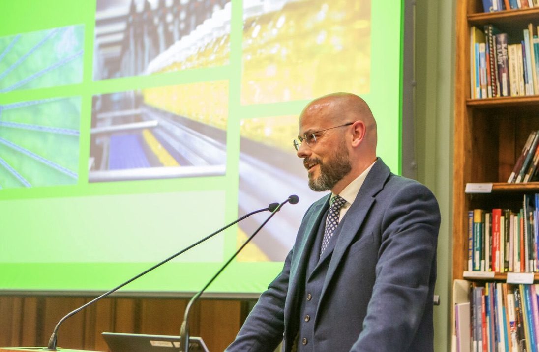 Mark Apsey speaking at a lectern with an IChemE presentation behind him