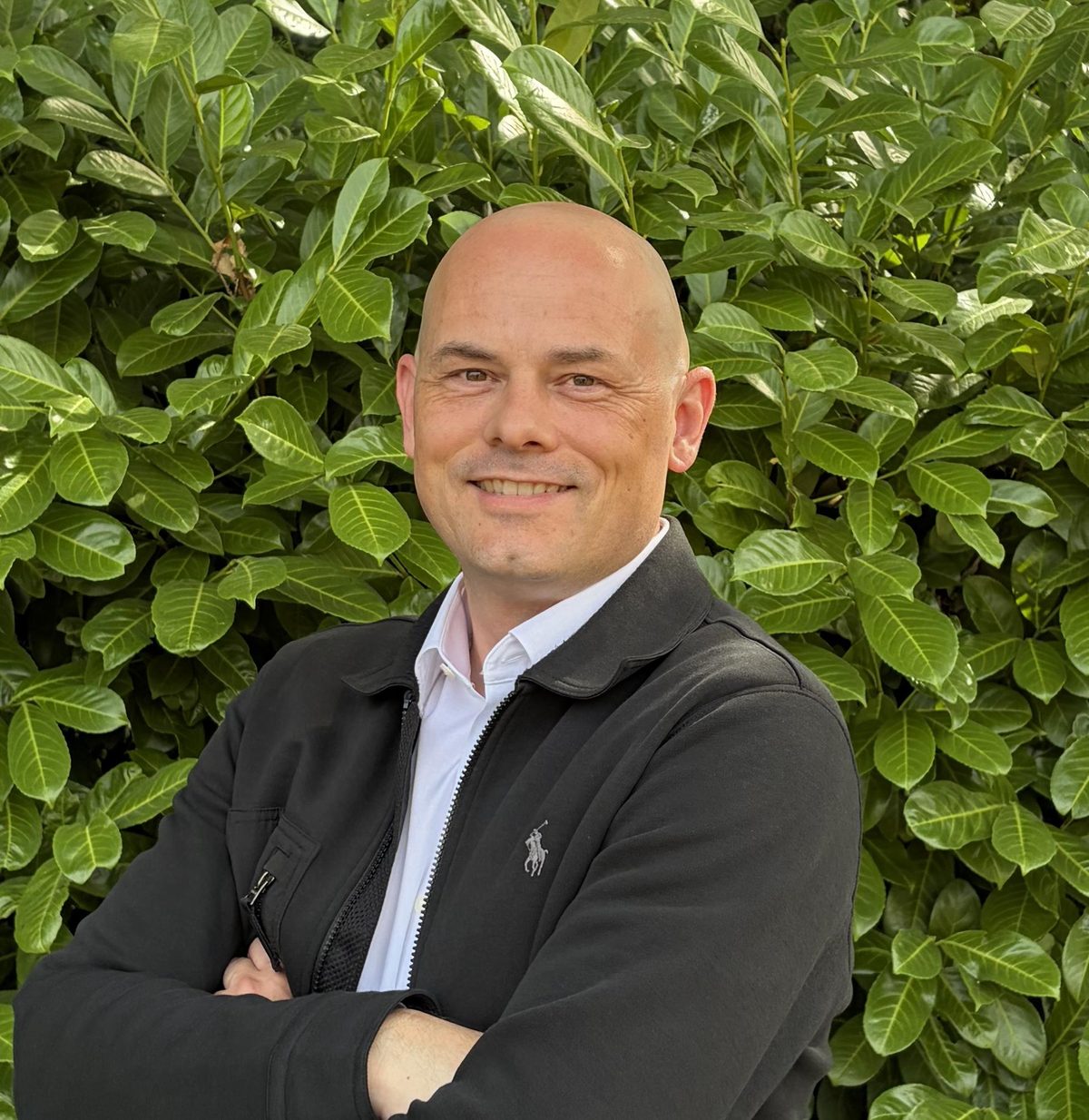 Mark Apsey outdoors, arms folded, in a dark jacket and white shirt